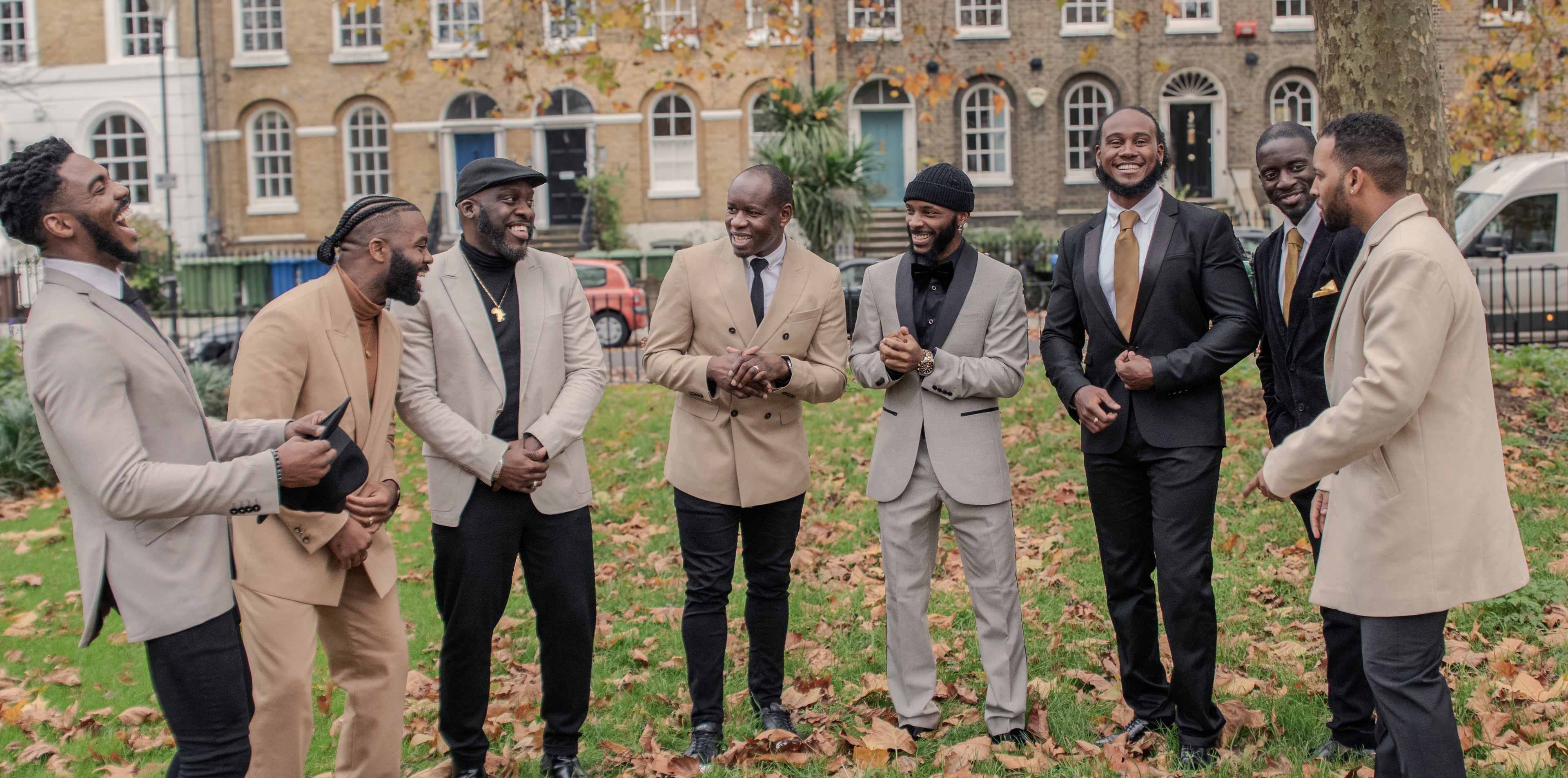 Eight KVG members standing together in a London garden, laughing