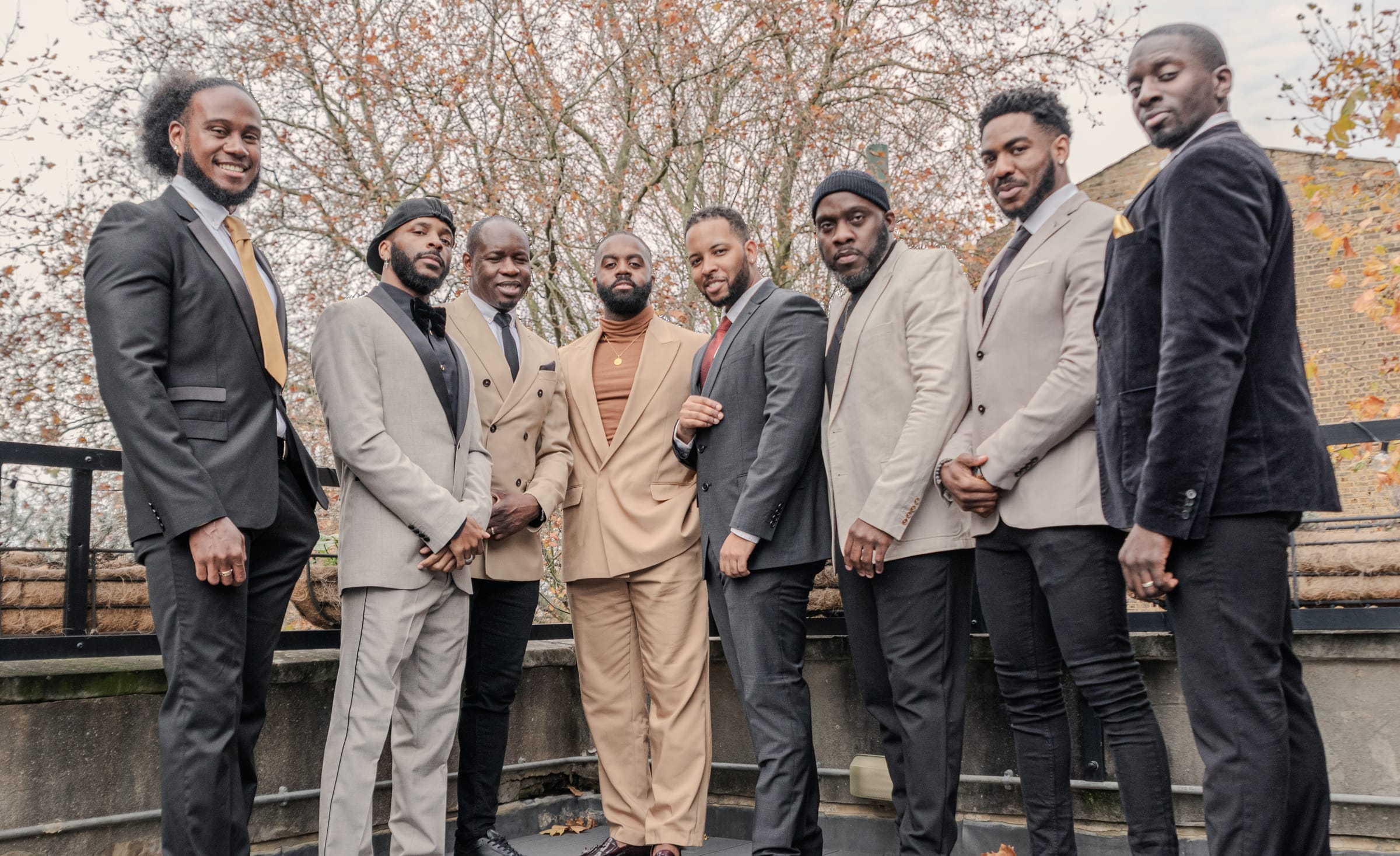 Eight KVG members standing in a line on a rooftop terrace in formal dress
